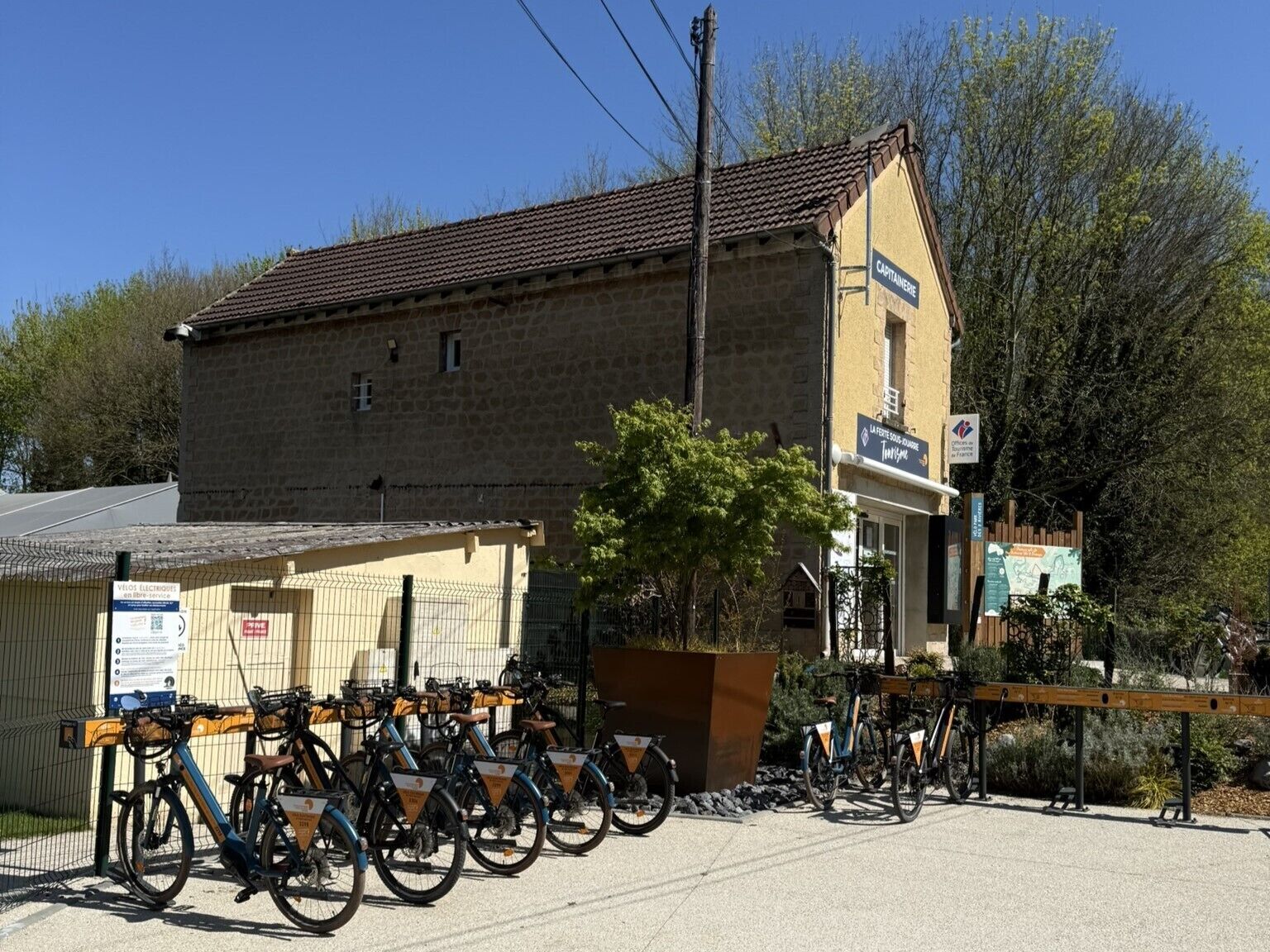A building with a stone facade, a sign reading "CAPITAINE", and a bicycle parking area with several bikes.
