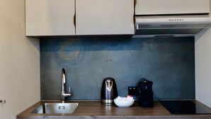 A kitchen with a stainless steel sink, a kettle, a coffee maker, and a built-in oven. - L'Escale Royale La Ferté-sous-Jouarre (La Ferté-sous-Jouarre)