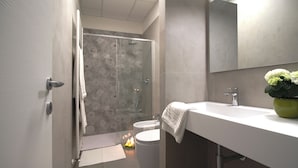 Un baño moderno con ducha, inodoro y lavabo.