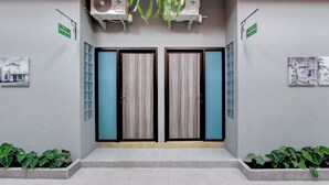 A reception area with two doors, air conditioning units, and potted plants. - Hotel O Yogyakarta near Jalan Malioboro formerly Malio Inn (Yogyakarta)