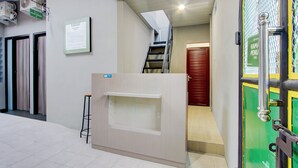 A hotel reception area with a reception desk, a staircase, and a door marked "KAMIN PENUN". - Hotel O Yogyakarta near Jalan Malioboro formerly Malio Inn (Yogyakarta)