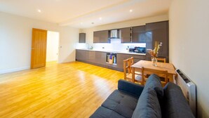 Un apartamento moderno con cocina, comedor y sala de estar con sofá.