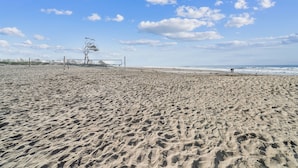 A sandy beach with footprints, a fence, and a tree. - Beautiful 1 Bed Beach Condo #224 1 Bedroom Condo by Sunset Shores Condominiums (Carpinteria)