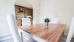 Un comedor moderno con una mesa de madera y sillas blancas.