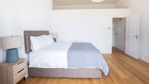 Une chambre à coucher moderne avec un lit, des tables de chevet et une armoire.