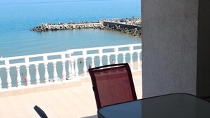 A balcony with a view of the sea and a rocky breakwater. - Hotel NOY (Varna)