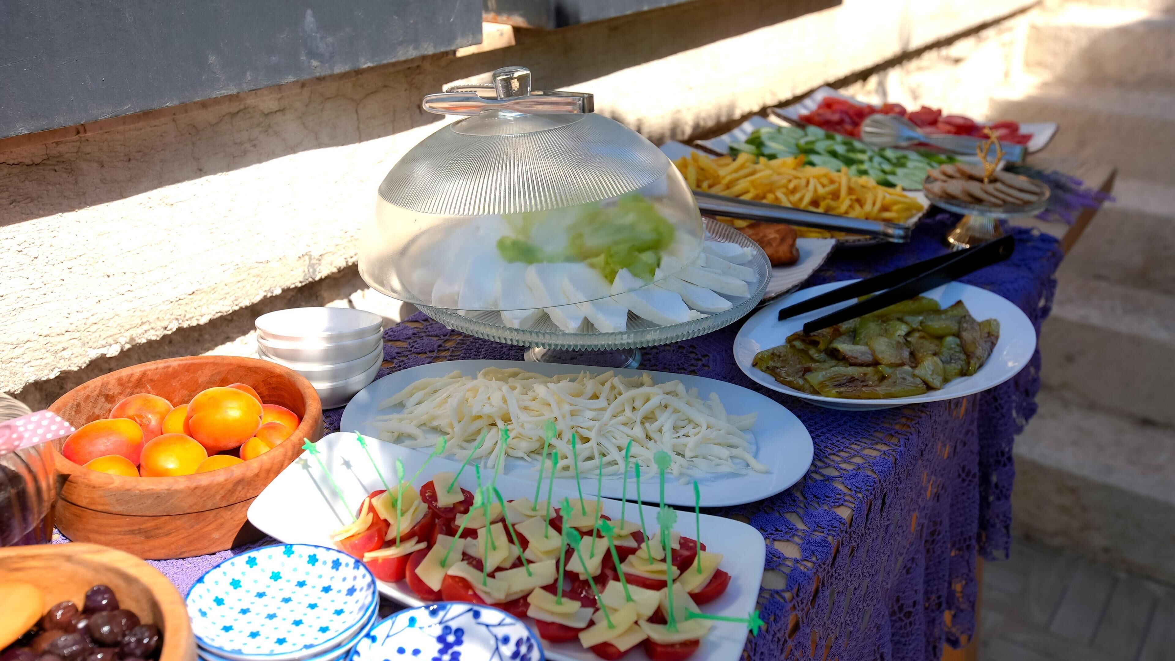 A buffet table with various food items and a decorative umbrella.