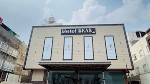 A building with a sign reading "Hotel EKAS" and four vertical windows with the same name.