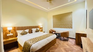 A modern hotel room with a large bed, a desk, and a chair.