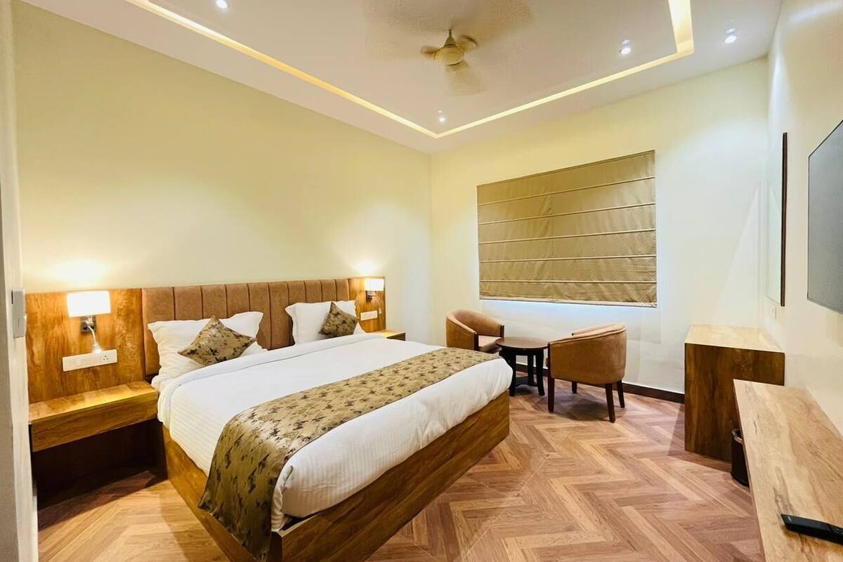 Una habitación de hotel moderna con una cama grande, un escritorio y una silla.