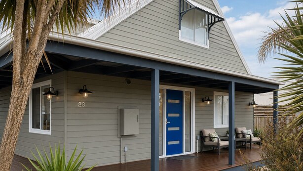 A house with a covered porch, a blue door, and a number '23' on the wall. - Horizon Loft by Ready Set Stay (Cowes)