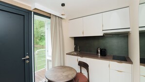 A compact kitchen with a built-in stove, a small dining table, and a chair. - L'Escale Royale Poissy Ile de Migneaux (Poissy)