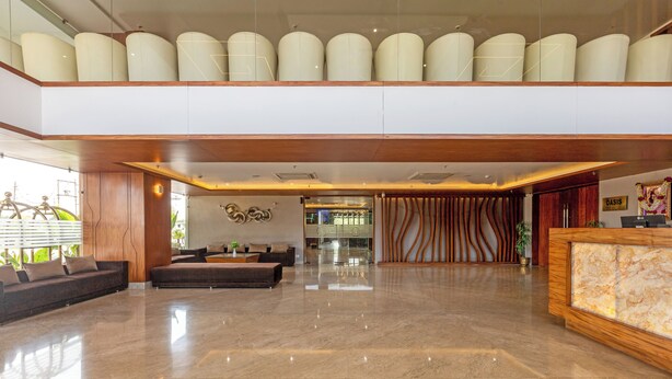 Eine großzügige Lobby mit poliertem Marmorboden, einem Empfangsbereich und einer Sitzecke mit Sofas.