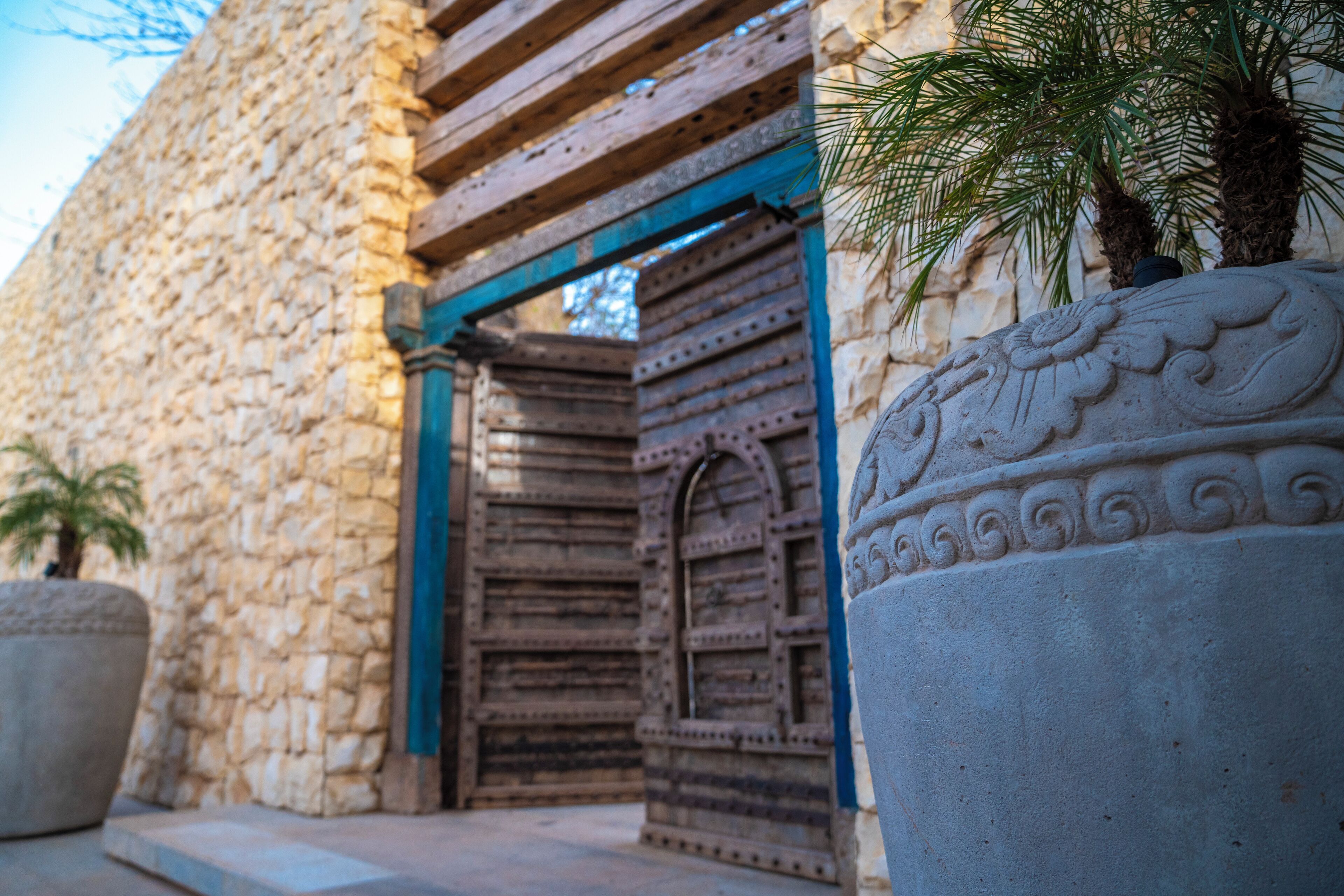 Un edificio de piedra con una puerta de madera y una columna decorativa.