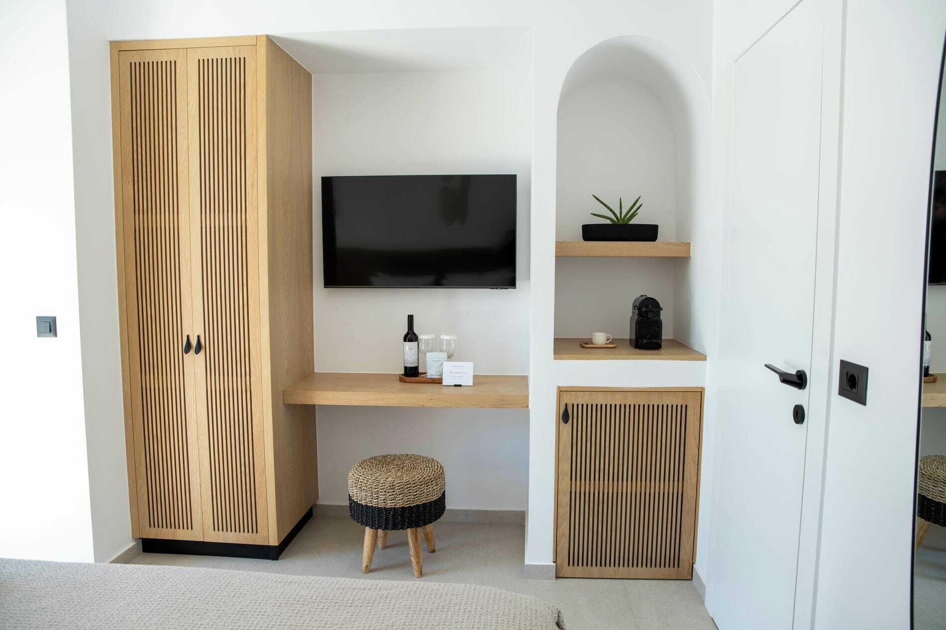 A modern room with a TV, wooden cabinet, and a small stool.