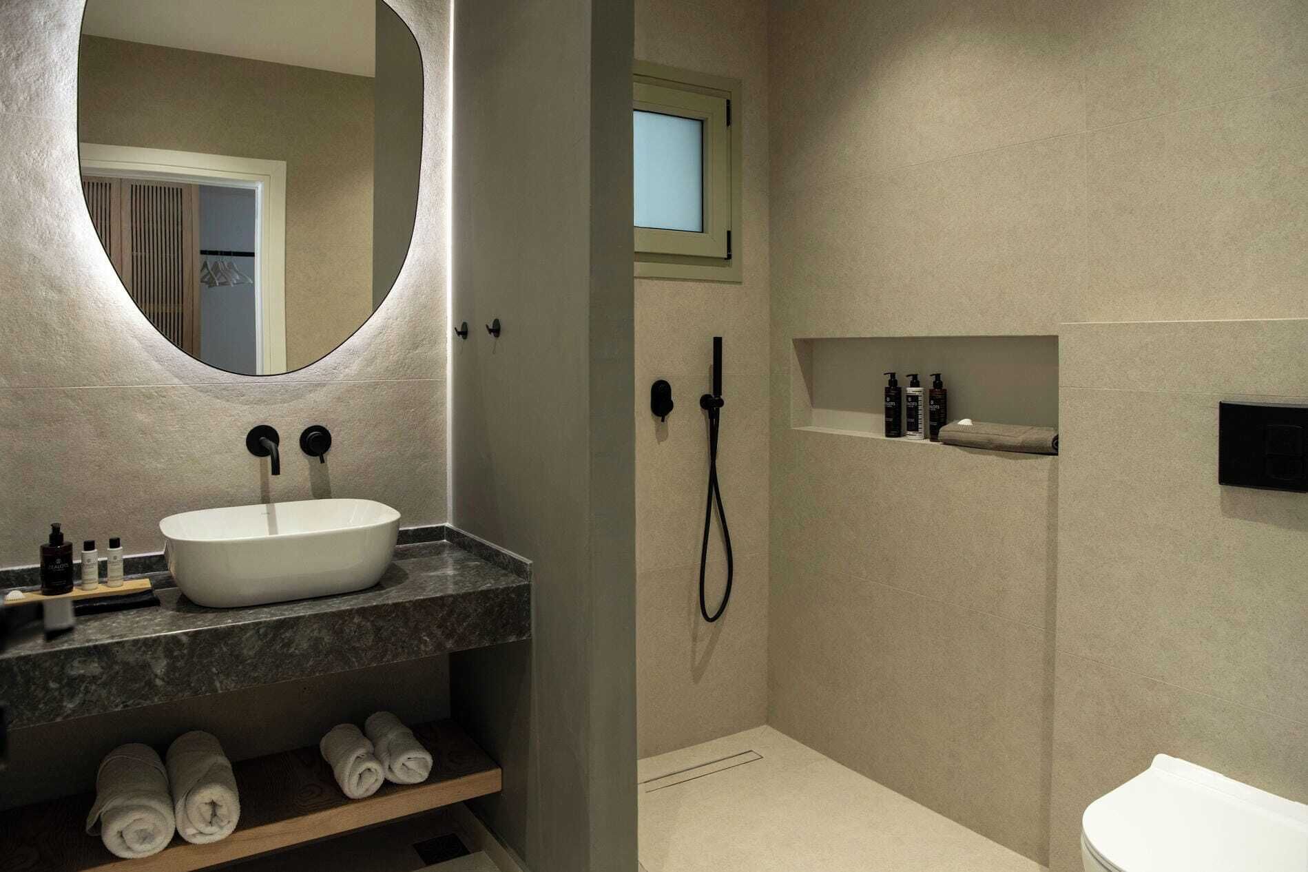 Un baño moderno con una bañera independiente, ducha y tocador con espejo.