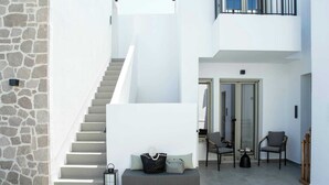 A modern interior with a staircase, seating area, and a balcony. - Kalea Suites (Milos)