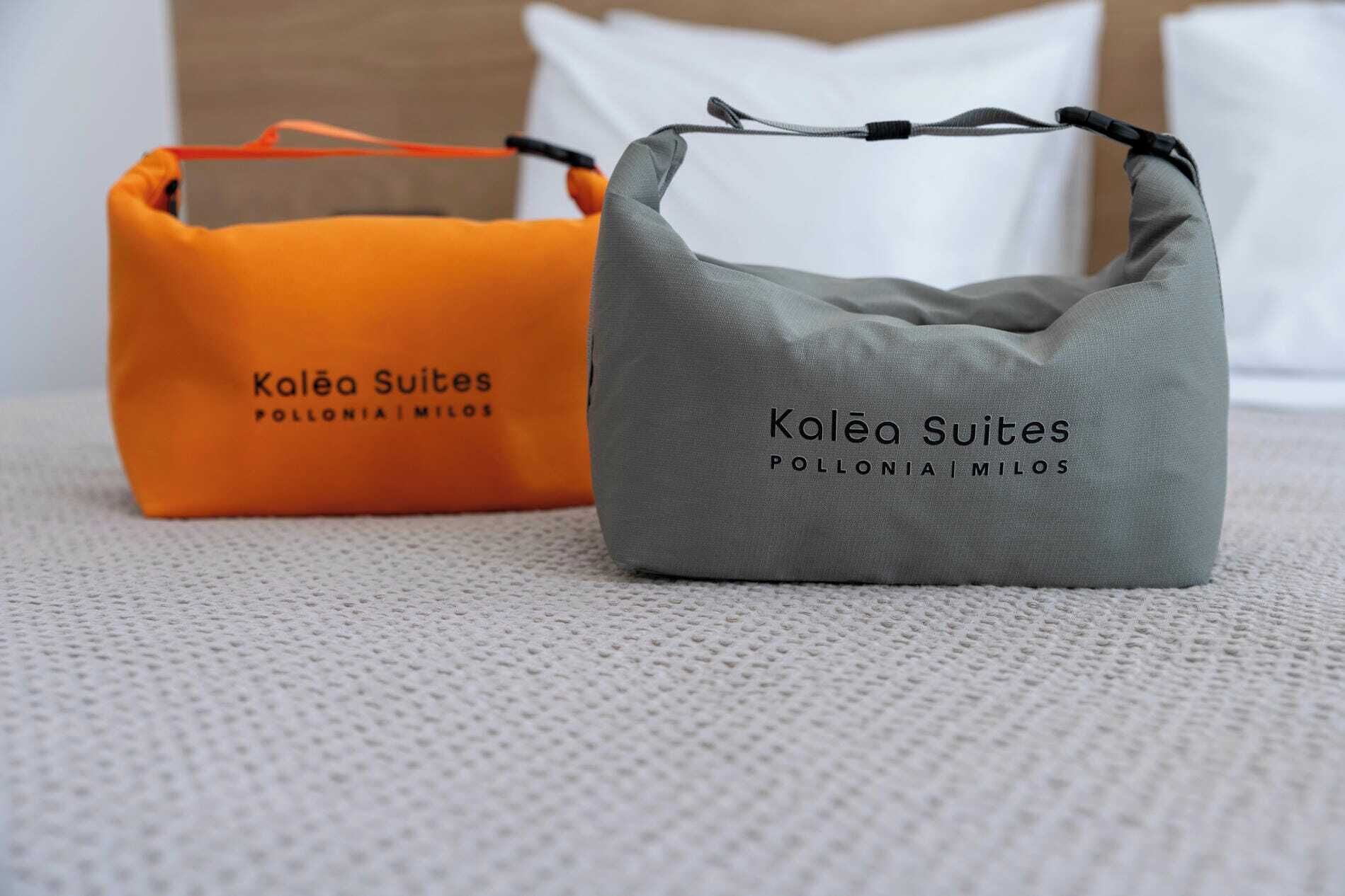 Dos maletas con el logotipo de 'Kaléa Suites' sobre una superficie rugosa.