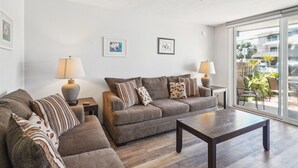 A living room with a sofa set, two side tables with lamps, and a ceiling fan.