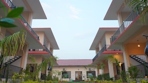 A hotel with a symmetrical facade, multiple balconies, and a central entrance.