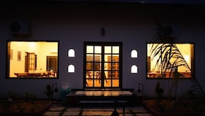 A building with a central entrance, two side windows, and a small outdoor seating area.