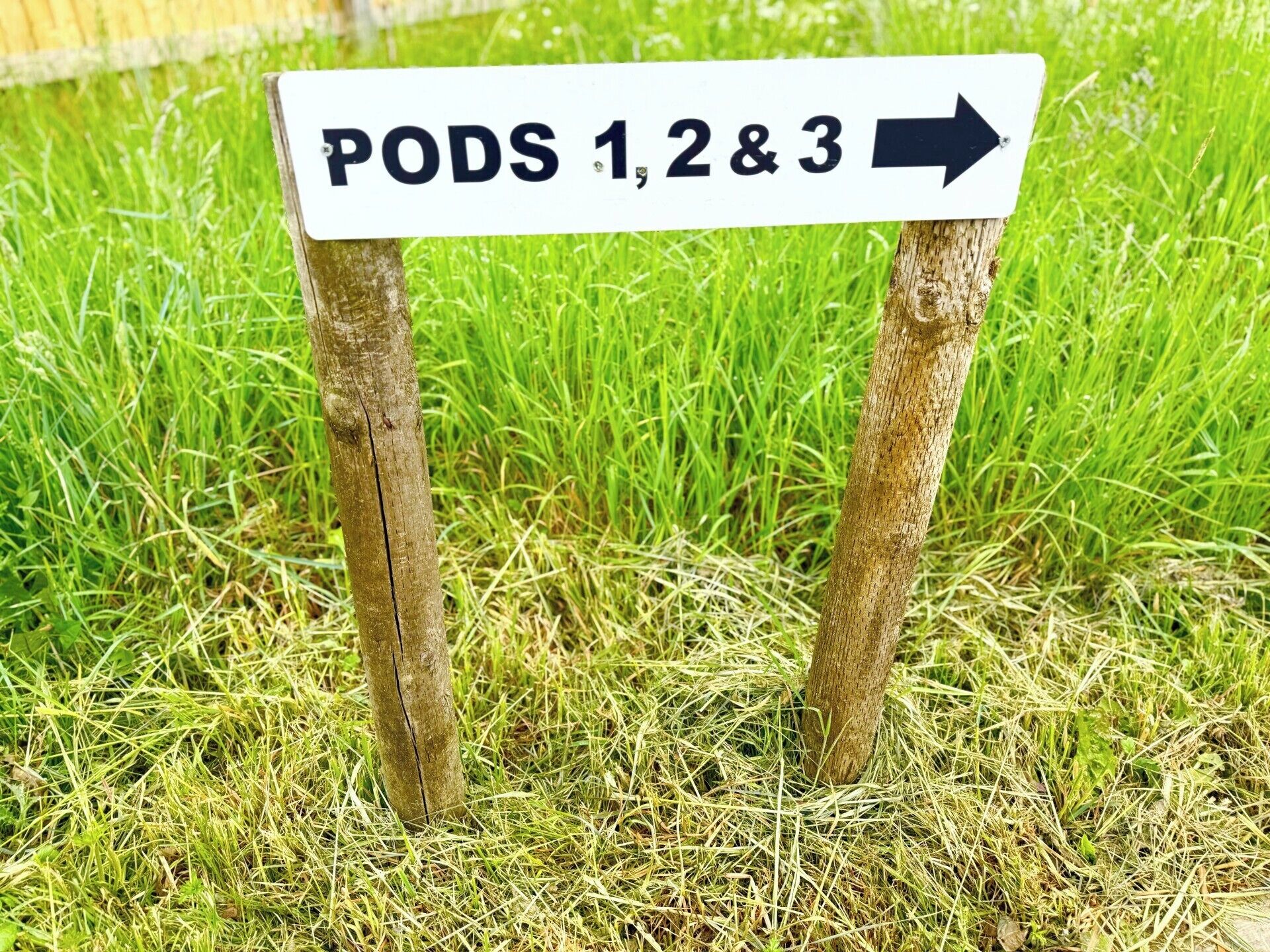 Un panneau de signalisation indiquant la direction des « PODS 1, 2 et 3 », avec une flèche pointant vers la droite.