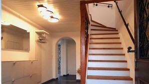 A hallway with a wooden staircase and a ceiling light fixture. - Vacation home TraunseeStrand EXKLUSIV in lakeside location incl. spacious garden (Ebensee)