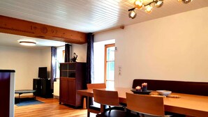 A dining area with a wooden table and chairs, a television, and a cabinet. - Vacation home TraunseeStrand EXKLUSIV in lakeside location incl. spacious garden (Ebensee)