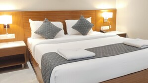 A hotel room with a large bed, two bedside tables, and wall-mounted lamps. - Hotel Sara Executive (Sawardari)