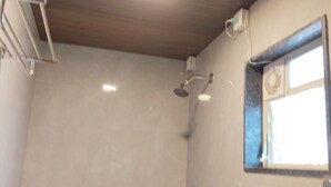 A bathroom with a shower, a window, and a ceiling fan. - Hotel Sara Executive (Sawardari)