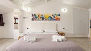 Una habitación de hotel con una cama grande, dos mesitas de noche, un cuadro en la pared y un armario.