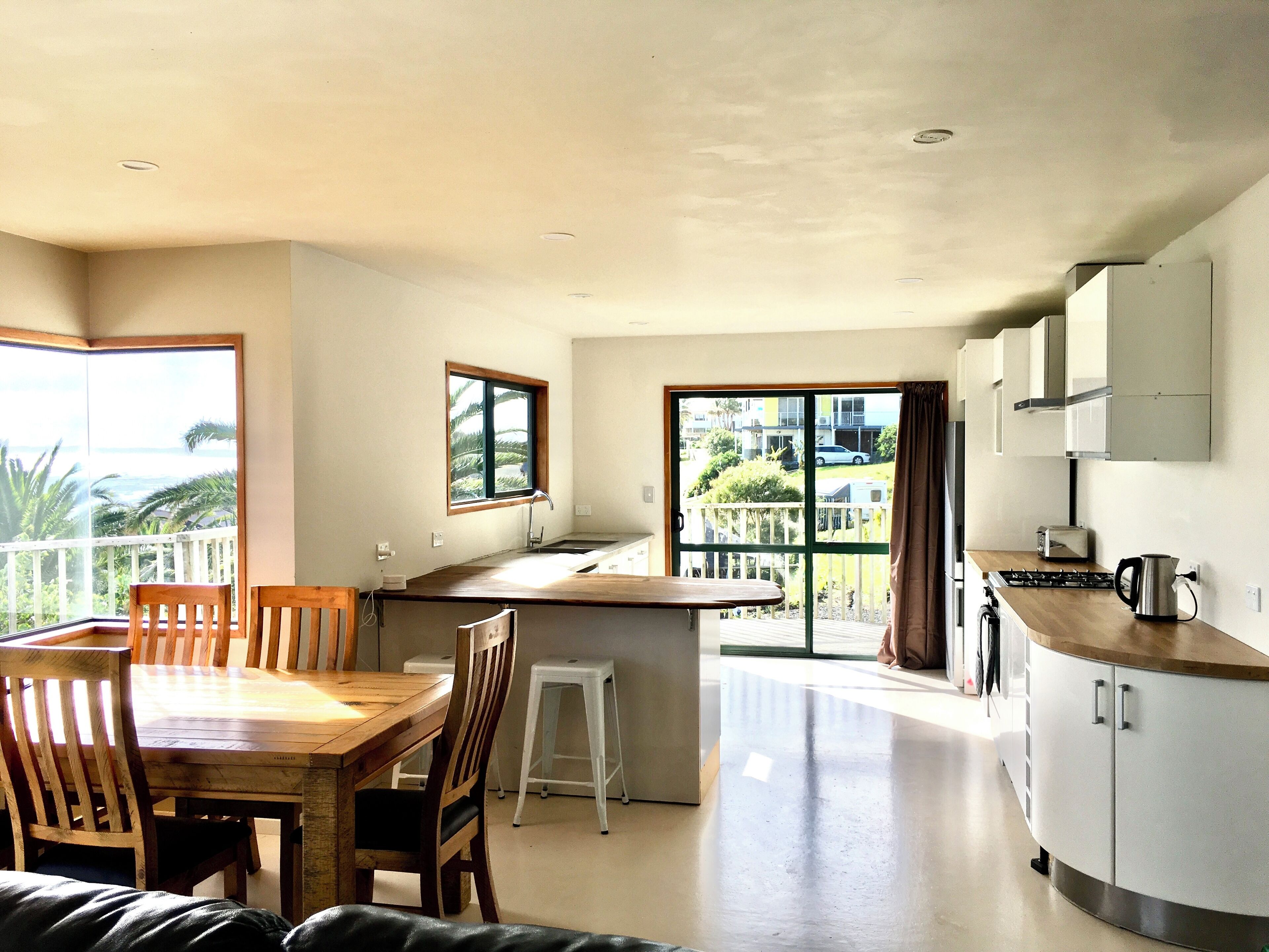 A compact kitchen with a dining area, a small island, and a view of the outdoors.