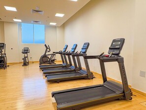 A fitness center with treadmills, ellipticals, and a stationary bike. - Bloomfields Spacious 1Br Water's Edge (Abu Dhabi)