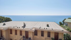 A building with a flat roof, multiple windows, and a view of the sea. - I Gabbiani sul Mare (Cervo)
