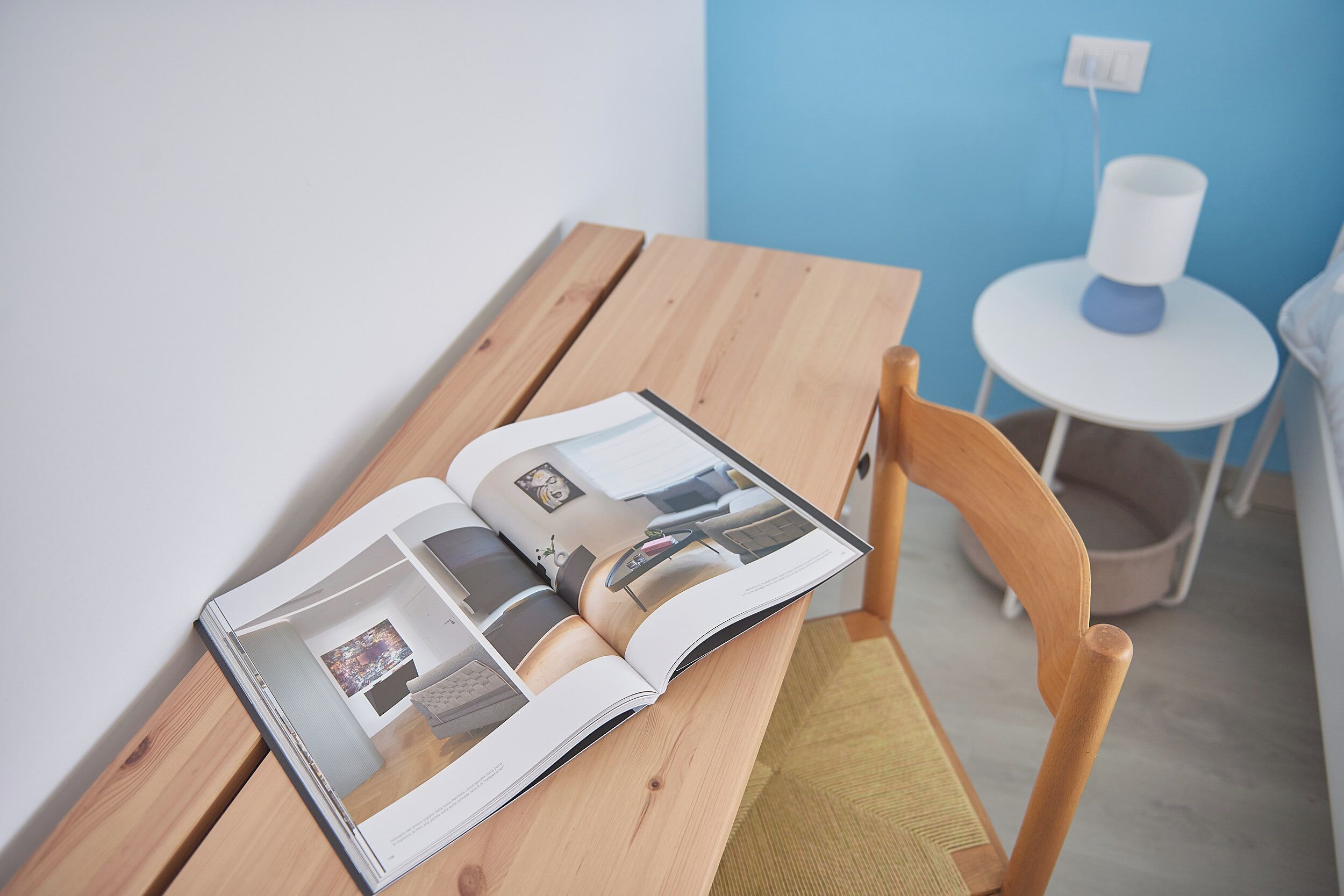 Revista aberta sobre uma mesa de madeira com uma cadeira.