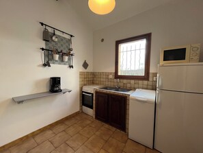 Enjoy cooking in this well-lit kitchen with an oven, microwave, and coffee maker.