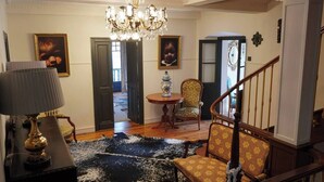 A spacious living room with a chandelier, a round table, and a staircase. - Casa Puebla - Cangas de Onís (Cangas de Onís)