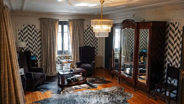 A room with a large mirror, a chandelier, a fireplace, and a patterned rug. - Casa Puebla - Cangas de Onís (Cangas de Onís)