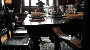 A dining table set with plates, bowls, and wine glasses, surrounded by ornate chairs. - Casa Puebla - Cangas de Onís (Cangas de Onís)