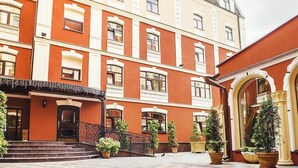 A multi-story building with a red facade, multiple windows, and a staircase leading to the entrance. - Optima Collection Podil Plaza (Kyiv)