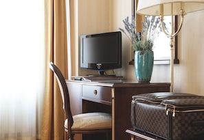Work from a spacious desk with a Samsung monitor, surrounded by a vase with fresh flowers and a comfortable chair.
