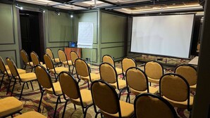 A conference room with rows of chairs and a large screen. - Optima Collection Podil Plaza (Kyiv)