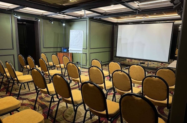 Conference room with a large projection screen and comfortable seating for presentations and meetings.