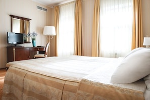 Relax in a spacious room with a large bed, TV, and comfortable seating area.