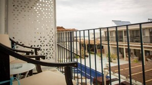 A balcony with a view of a pool and a building with a flat roof. - The Moon Villas (Vama Veche)