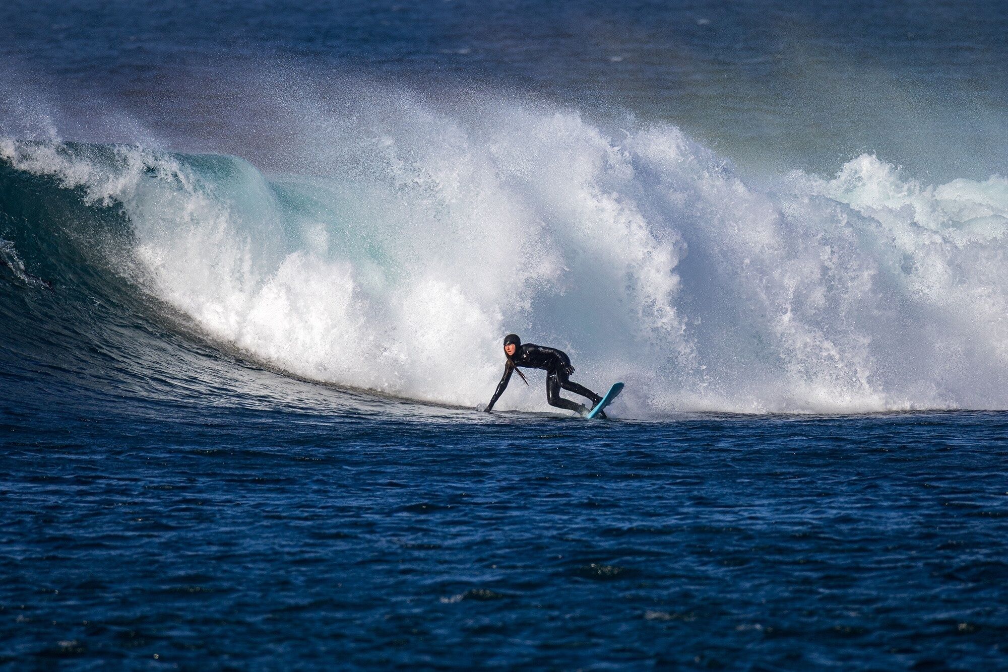 Ein Surfer reitet auf einer hohen Welle im Meer.