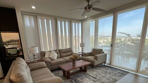 Un salon spacieux doté d’une grande fenêtre, d’un ventilateur de plafond et offrant une vue sur l’extérieur.