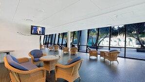 A spacious indoor area with wicker furniture, large windows, and a flat-screen TV. - Level 29 Oceanfront & City Horizon Bliss (Gold Coast)