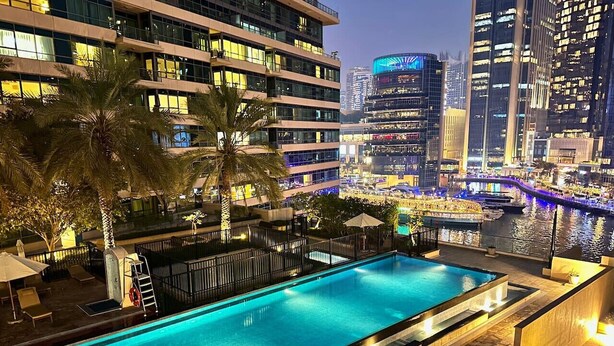 A swimming pool with a view of a cityscape at night.