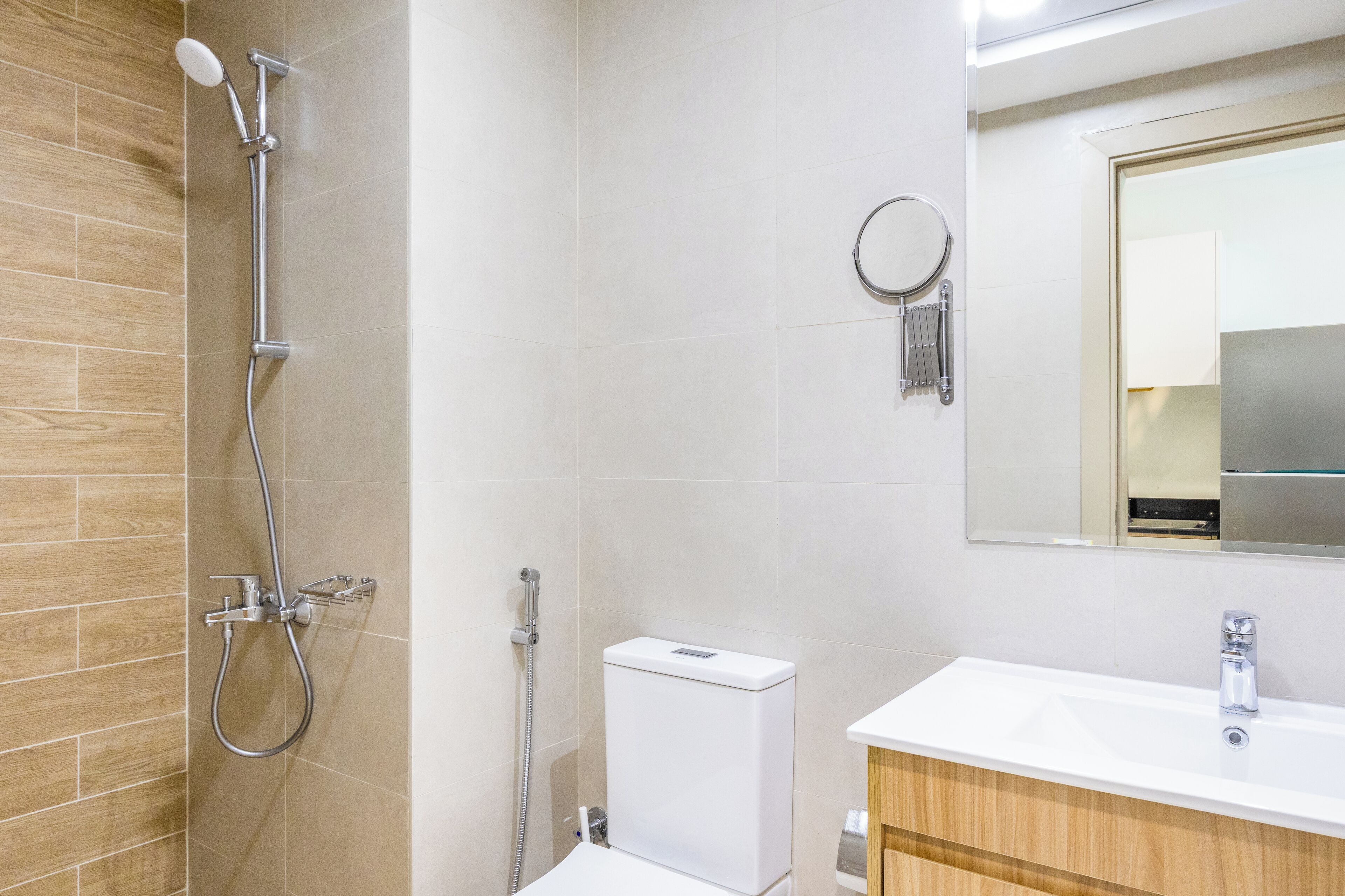 A modern bathroom with a shower, toilet, and sink.